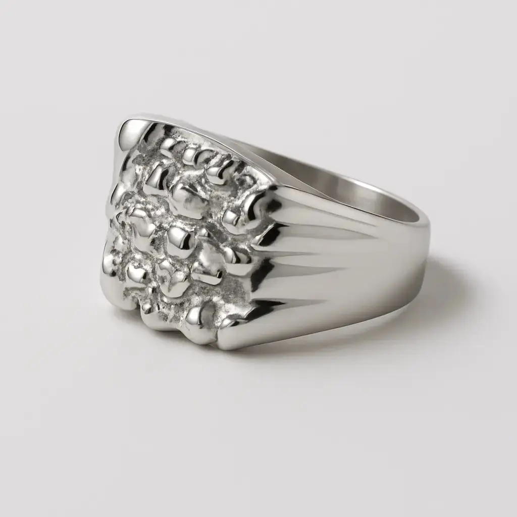 Silver nugget  ring with a detailed design on a light gray background